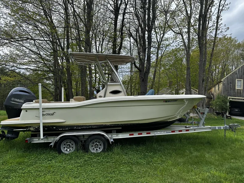 Slide: The Image of 2018 Scout 225 XSF boat on trailer in grassy area with trees. - 2