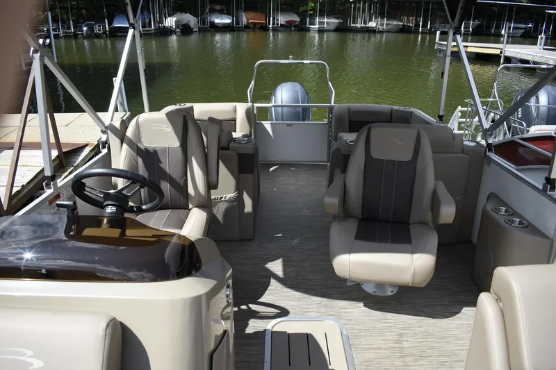 Slide: The Image of 2023 Bennington 22 SXCW pontoon boat interior with plush seating and steering console. - 10