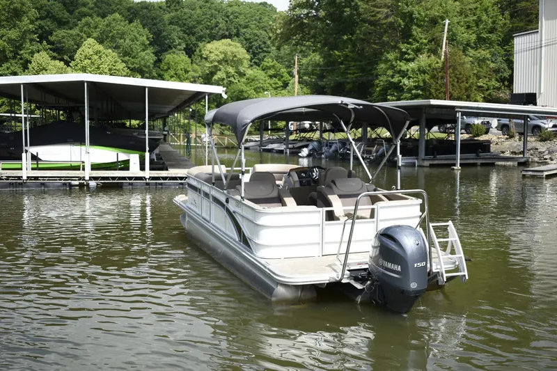 Slide: The Image of 2023 Bennington 22 SXCW pontoon boat docked on a calm lake. - 4