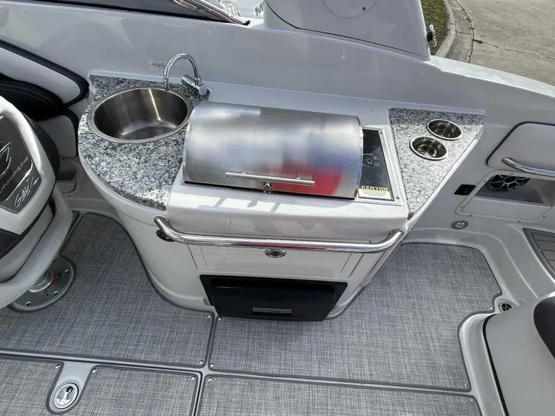 Slide: The Image of 2024 Crownline E280 XS boat interior with kitchenette, sink, and grill. - 8