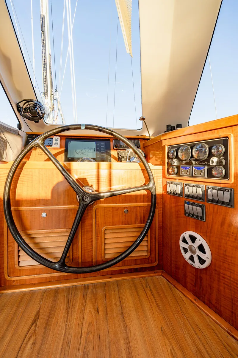 Slide: The Image of Steering wheel and control panel of 2009 Chris White Atlantic 57 yacht, featuring wooden interior. - 9