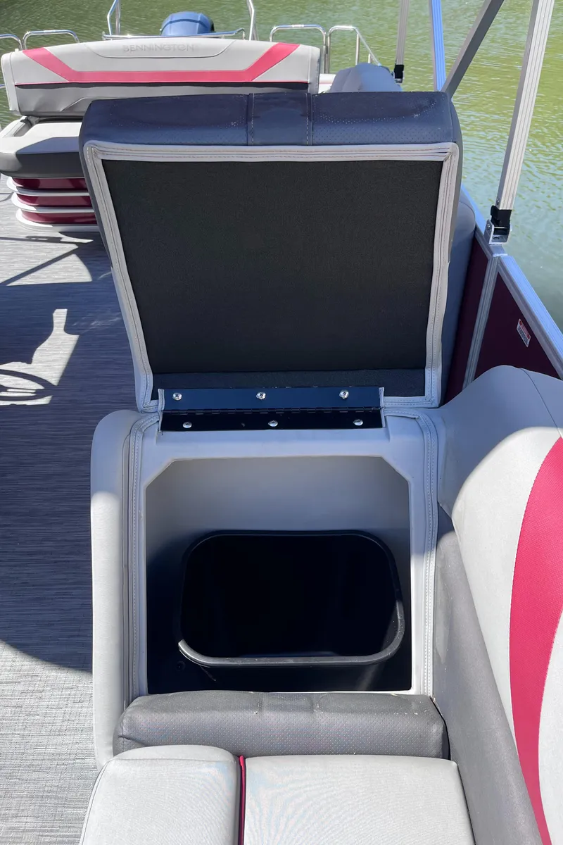 Slide: The Image of 2023 Bennington 23 SXSB boat seat storage compartment with open lid, revealing interior space. - 13