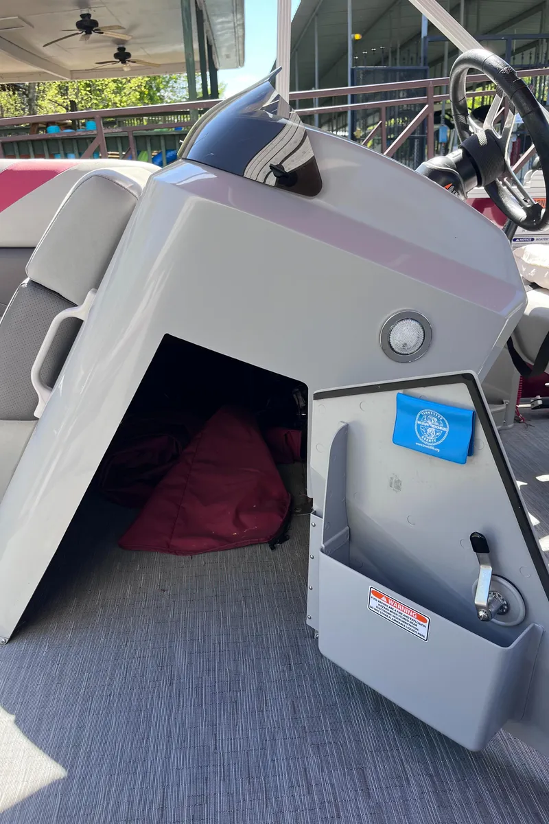 Slide: The Image of 2023 Bennington 23 SXSB boat interior with storage compartment and steering wheel. - 14