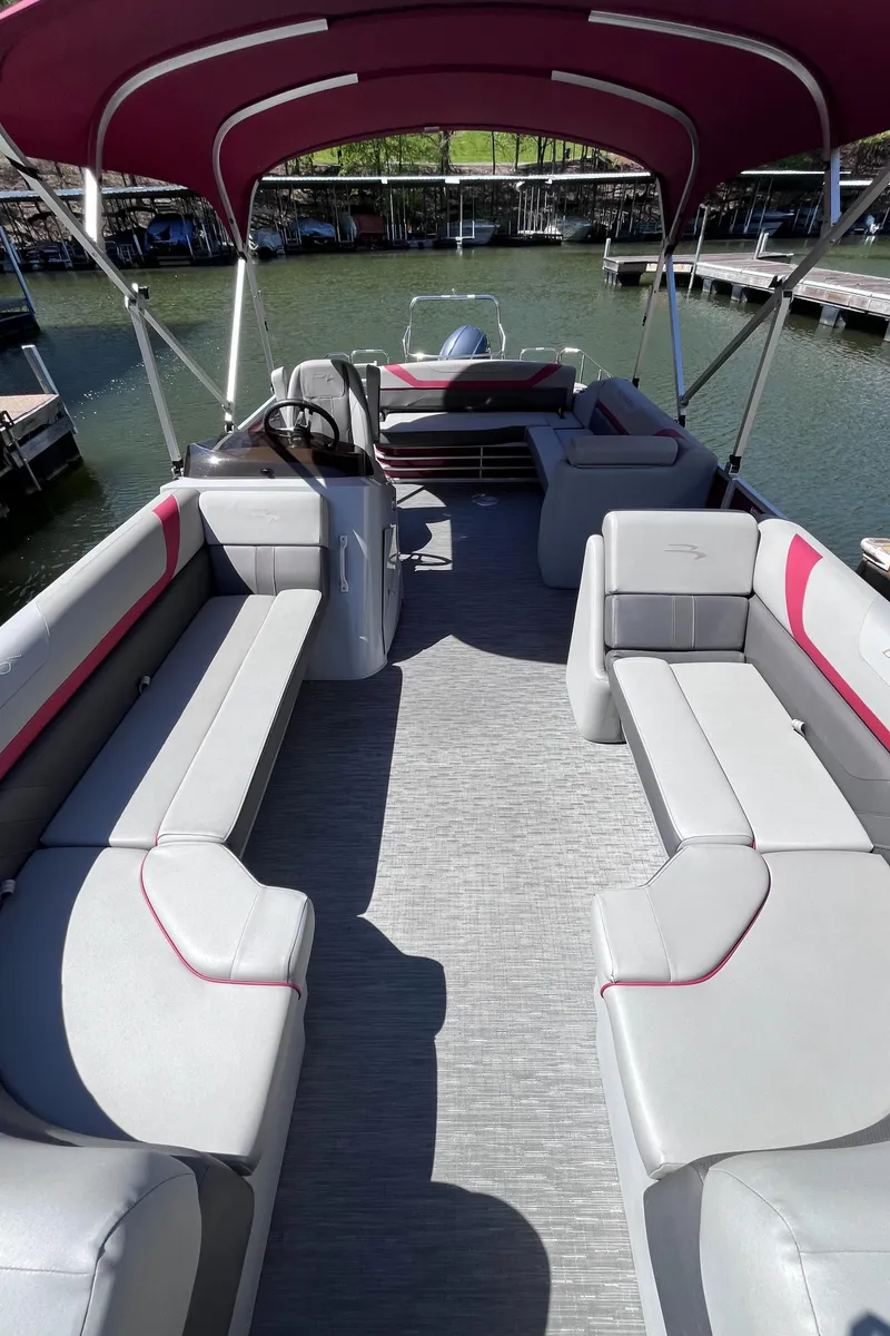 Slide: The Image of 2023 Bennington 23 SXSB pontoon boat with spacious seating and canopy on a calm lake. - 4