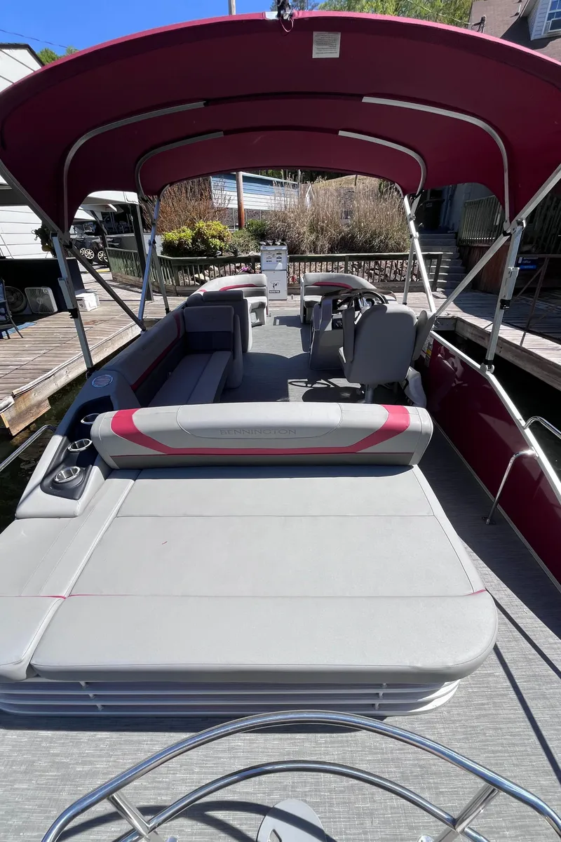 Slide: The Image of 2023 Bennington 23 SXSB pontoon boat with red canopy and spacious seating. - 5