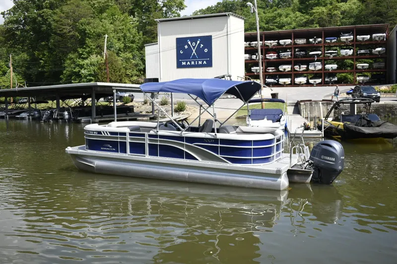 Slide: The Image of 2023 Bennington 23 SXSRC pontoon boat docked at a marina. - 2