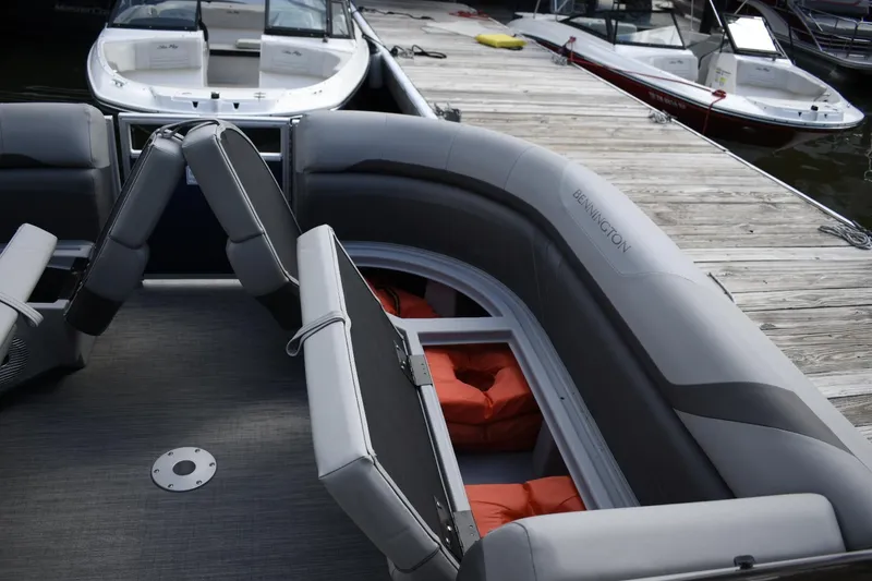 Slide: The Image of 2023 Bennington 23 SXSRC pontoon boat interior with gray seating and orange life jackets. - 5