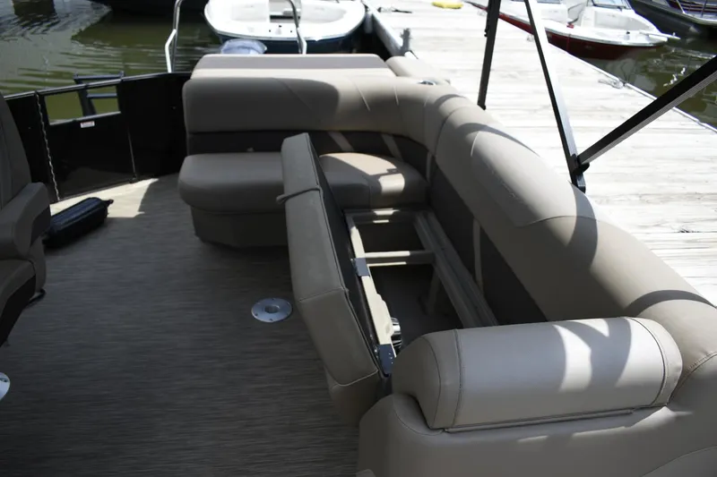 Slide: The Image of 2023 Bennington 23 XSL3 pontoon boat interior with beige seating and storage compartments. - 10