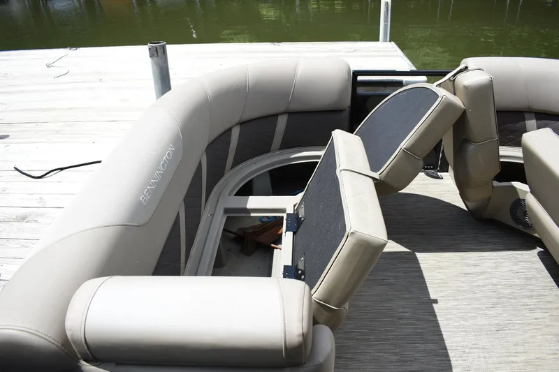 Slide: The Image of 2023 Bennington 23 XSL3 pontoon boat with beige seating and storage compartments. - 7