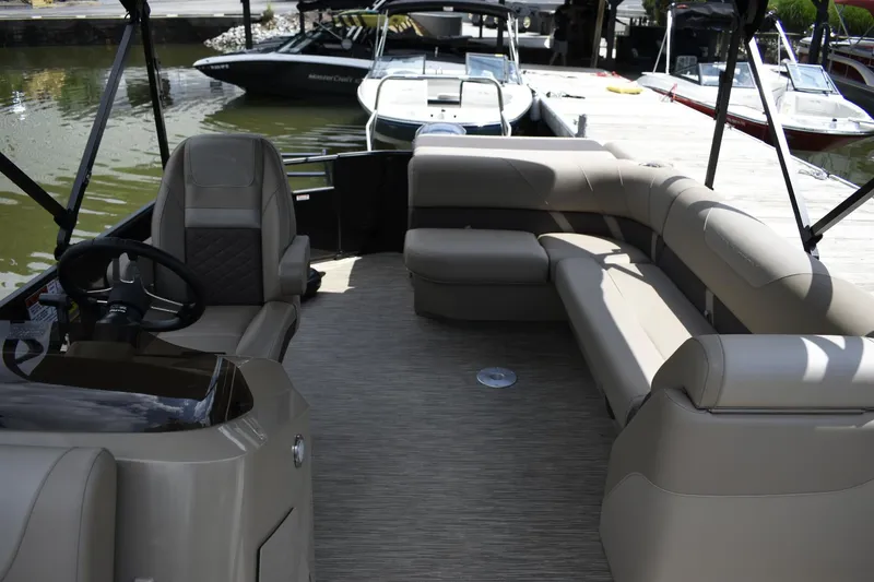 Slide: The Image of 2023 Bennington 23 XSL3 pontoon boat interior with plush seating and steering console. - 9