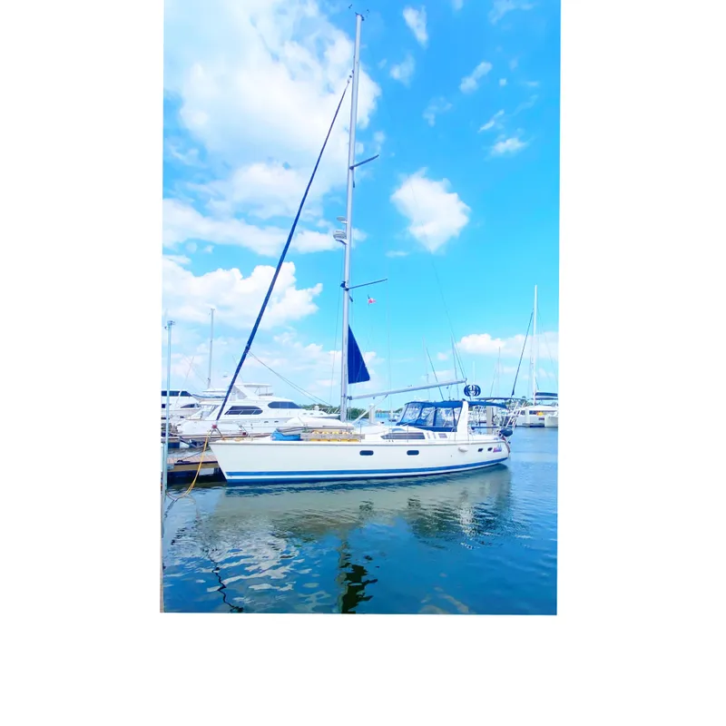 The Image of 1997 Hunter 430 sailboat docked at marina under blue sky. - 0