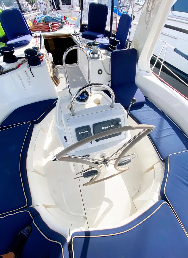 Slide: The Image of Cockpit of 1997 Hunter 430 sailboat with blue cushioned seating and steering wheel. - 10