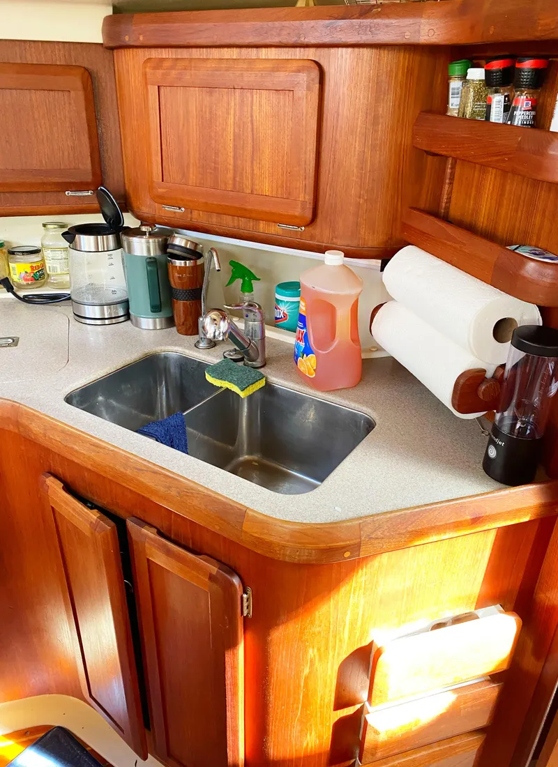 Slide: The Image of 1997 Hunter 430 yacht kitchen with wooden cabinets, sink, and countertop appliances. - 15