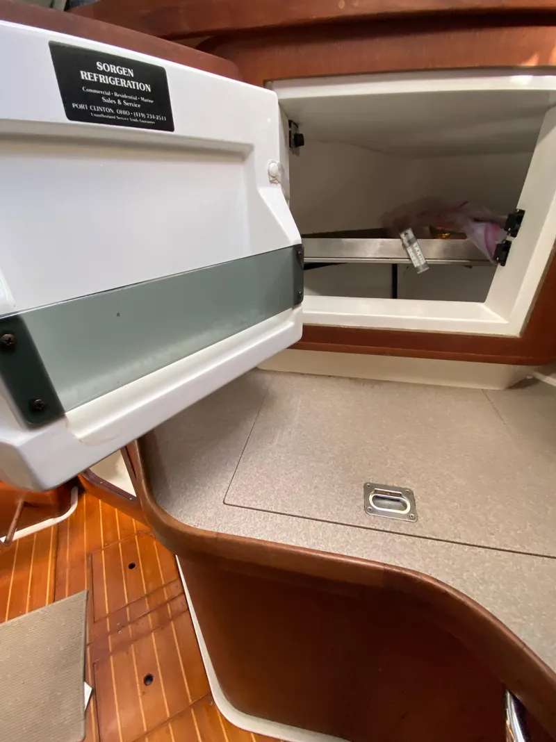 Slide: The Image of Interior of a 1997 Hunter 430 sailboat showing a storage compartment and wooden flooring. - 20