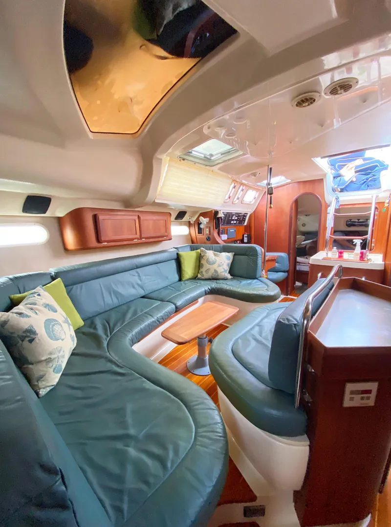 Slide: The Image of Interior of a 1997 Hunter 430 yacht with plush seating and wooden accents. - 21