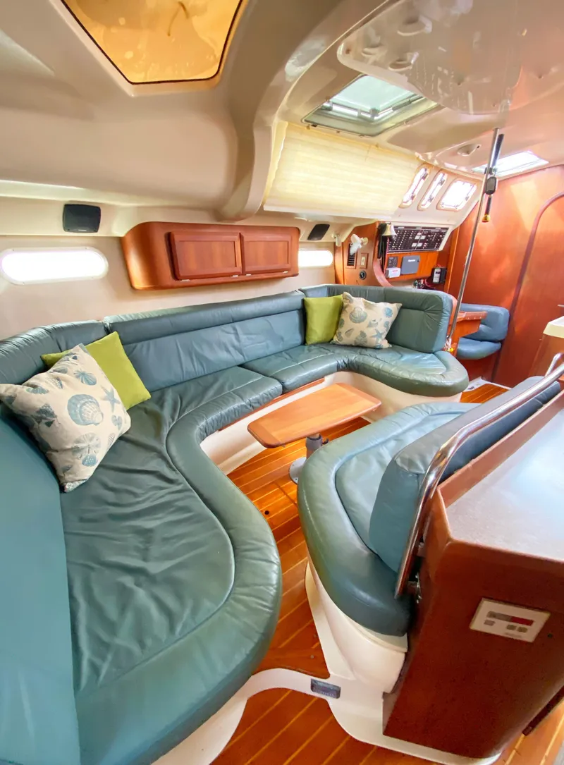 Slide: The Image of Interior of a 1997 Hunter 430 yacht with plush seating and wooden accents. - 22