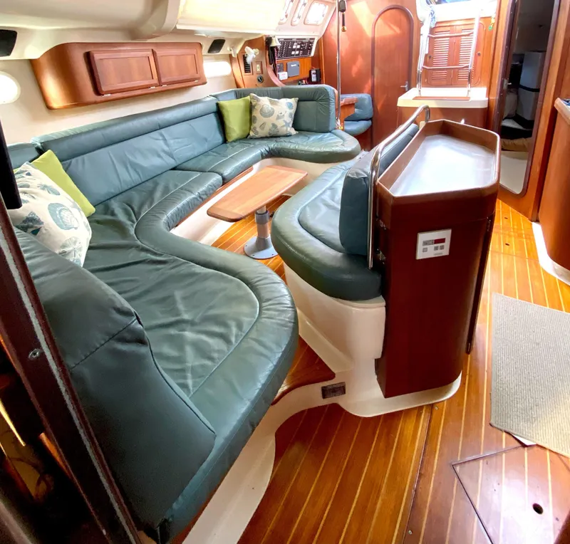 Slide: The Image of Luxurious 1997 Hunter 430 yacht interior with green leather seating and wooden flooring. - 23