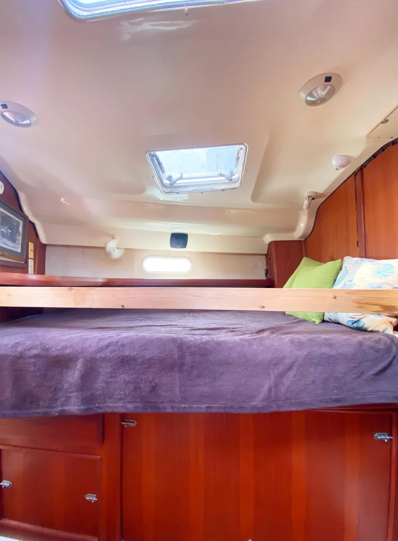 Slide: The Image of Interior cabin of a 1997 Hunter 430 sailboat with cozy bedding and wooden finish. - 29