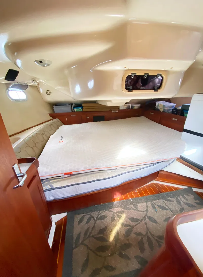 Slide: The Image of Interior of a 1997 Hunter 430 yacht, featuring a cozy cabin with a bed. - 38