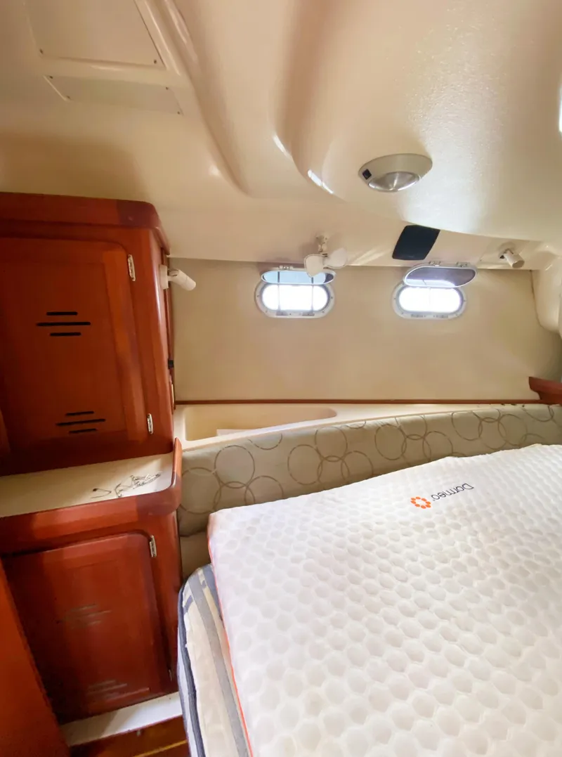 Slide: The Image of Interior cabin of a 1997 Hunter 430 sailboat with wooden cabinetry and bedding. - 39