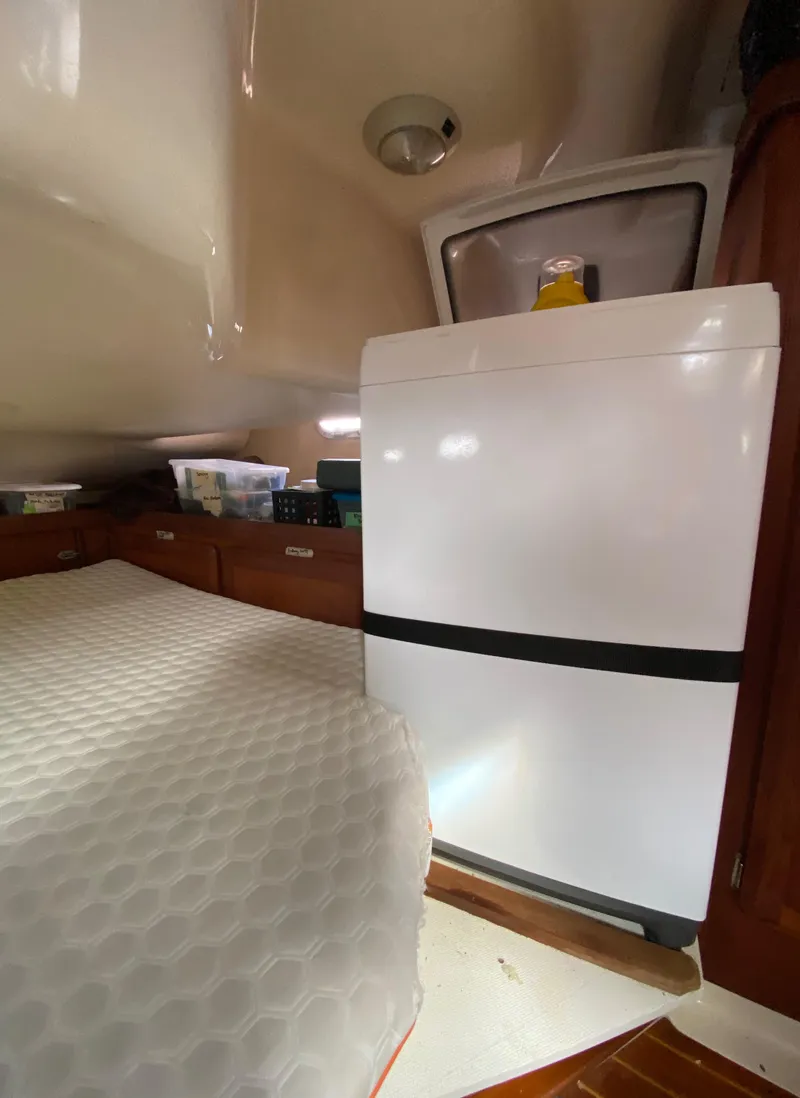 Slide: The Image of Interior of a 1997 Hunter 430 yacht with a compact fridge and storage. - 42