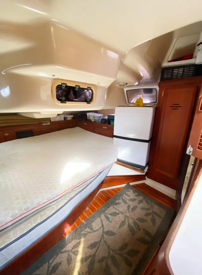 Slide: The Image of Interior of a 1997 Hunter 430 sailboat cabin with bed, fridge, and storage. - 43