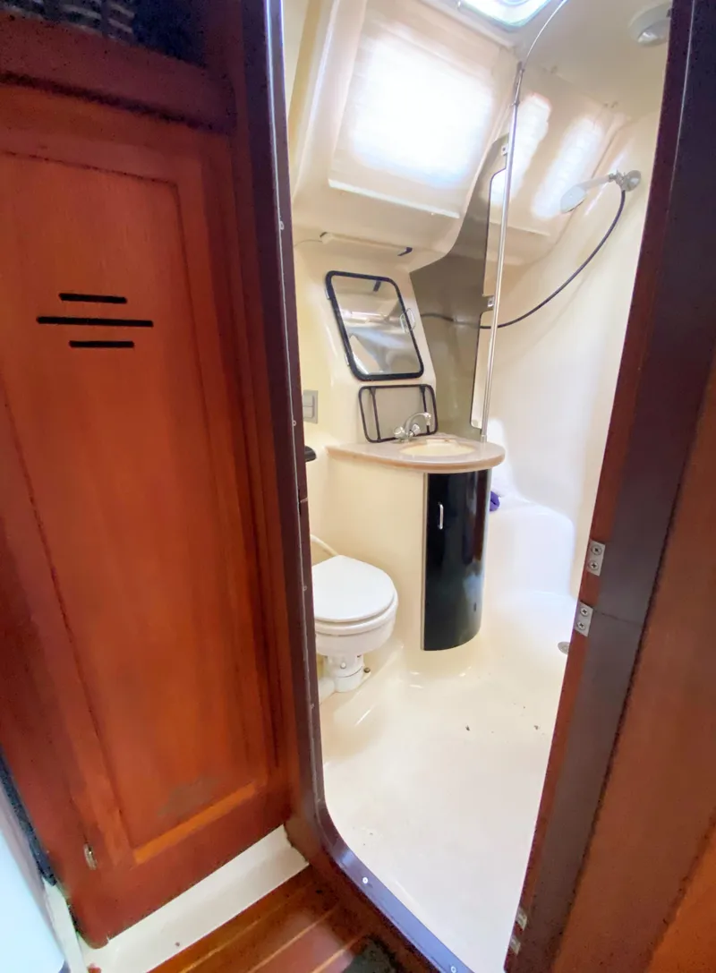 Slide: The Image of Interior of 1997 Hunter 430 sailboat bathroom with shower and wooden cabinetry. - 44