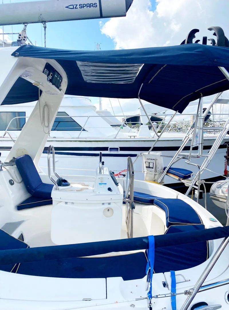 Slide: The Image of 1997 Hunter 430 sailboat with blue canopy, docked at marina. - 8