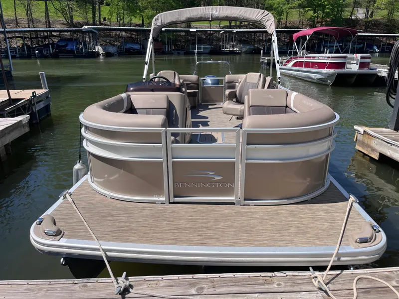 The Image of 2023 Bennington 22 SXSR pontoon boat docked at a marina, featuring spacious seating. - 1