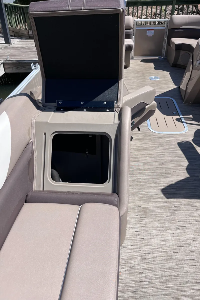 Slide: The Image of 2023 Bennington 22 SXSR boat interior with open storage compartment and beige seating. - 11
