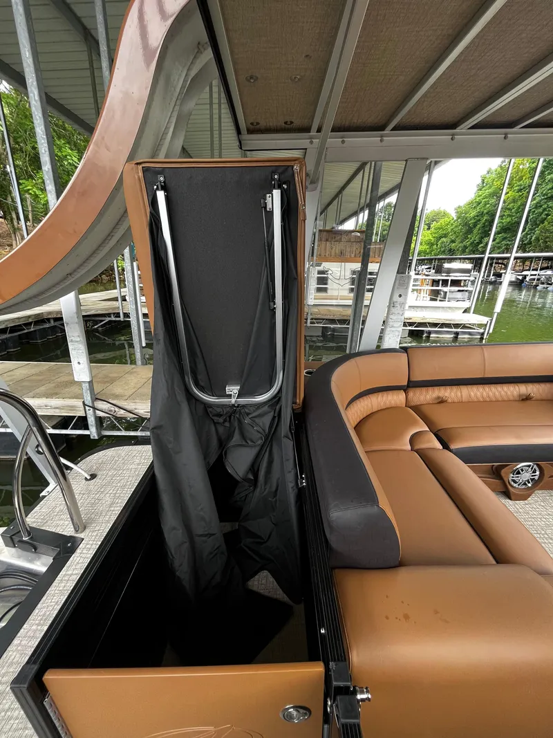 Slide: The Image of 2024 Avalon Catalina Funship 25' interior with brown seating and storage compartment. - 34