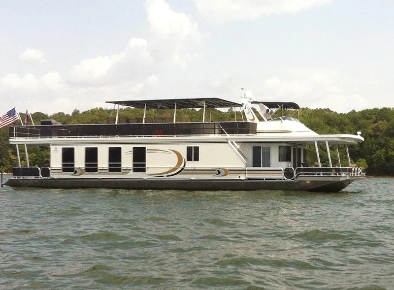Slide: The Image of 2003 Sharpe 75' Houseboat on a lake with trees in the background. - 0