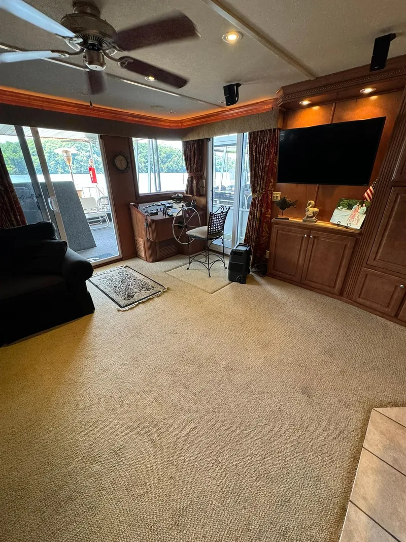 Slide: The Image of Interior of a 2003 Sharpe 75' Houseboat with carpet, TV, and outdoor view. - 20