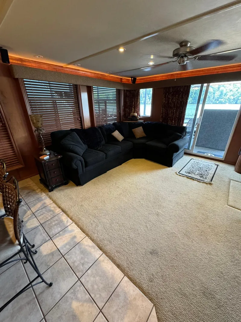 Slide: The Image of Spacious living area in a 2003 Sharpe 75' Houseboat with a large sectional sofa and sliding glass door. - 21