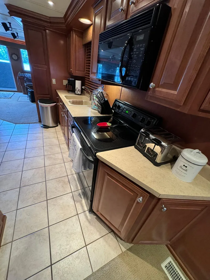 Slide: The Image of 2003 Sharpe 75' Houseboat kitchen with modern appliances and wooden cabinetry. - 26