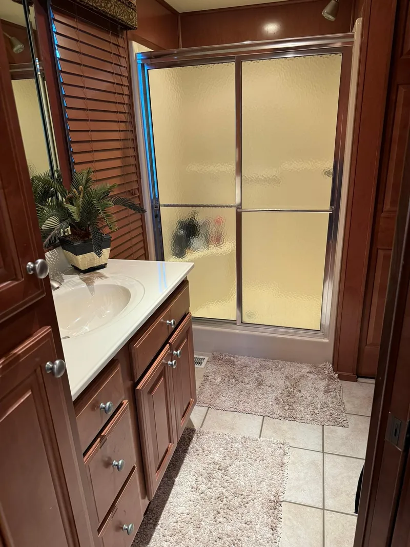 Slide: The Image of Bathroom in a 2003 Sharpe 75' Houseboat with wooden cabinets and a glass shower. - 32