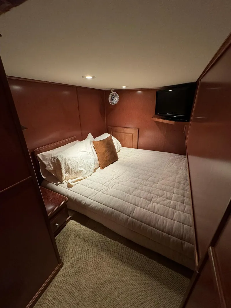 Slide: The Image of Cozy bedroom in a 2003 Sharpe 75' Houseboat with wood paneling and a mounted TV. - 37
