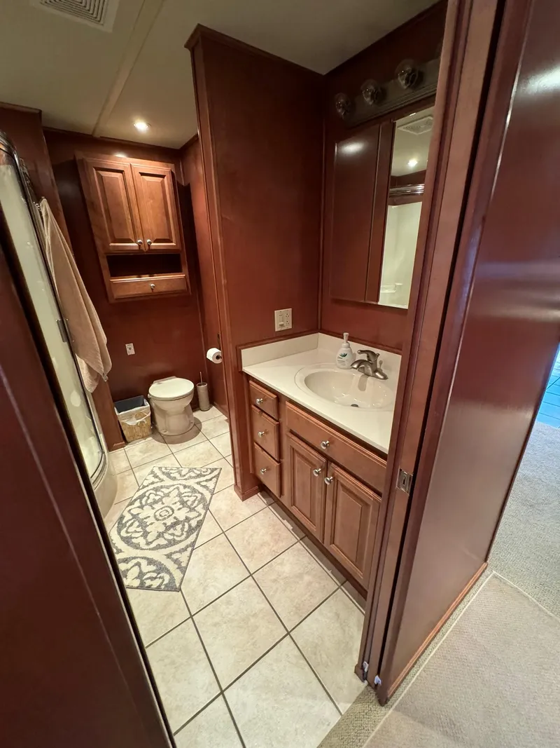 Slide: The Image of 2003 Sharpe 75' Houseboat bathroom with wooden cabinets, sink, and tiled floor. - 38