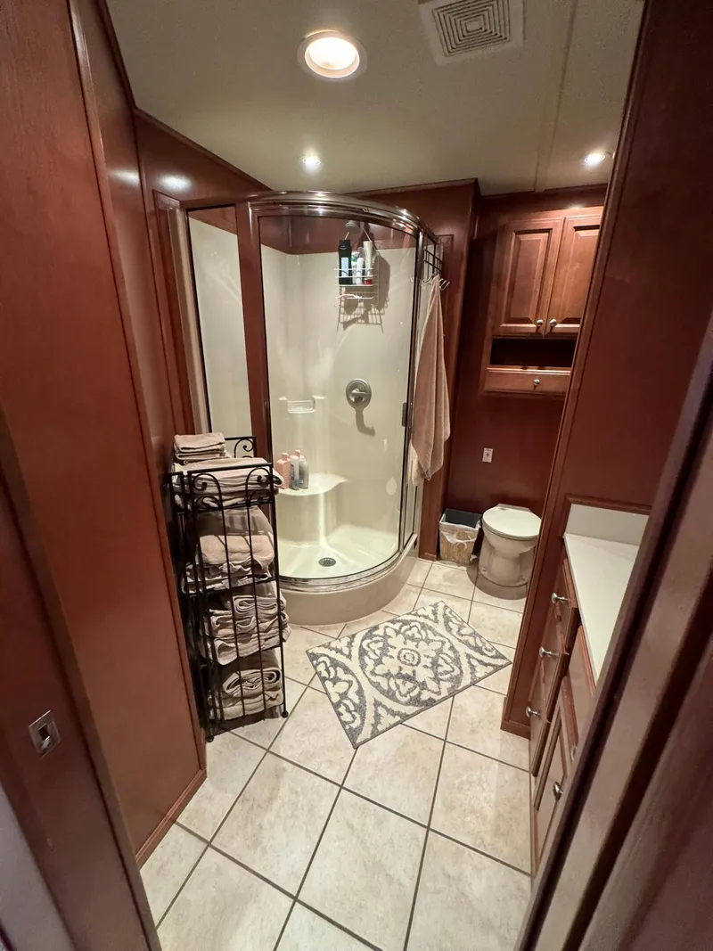 Slide: The Image of Bathroom in 2003 Sharpe 75' Houseboat with shower, wooden cabinets, and tiled floor. - 39