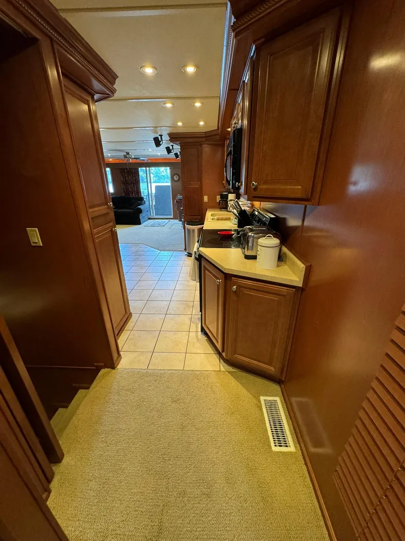 Slide: The Image of 2003 Sharpe 75' Houseboat interior with wooden cabinets and tiled flooring. - 41