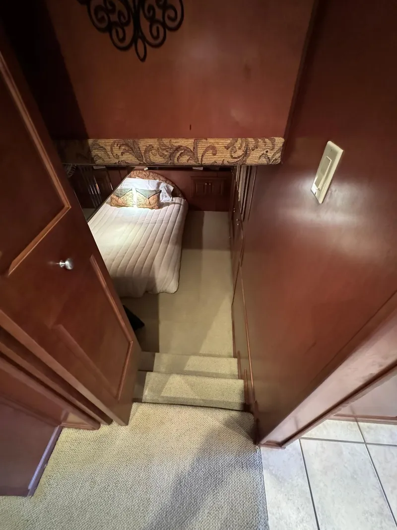 Slide: The Image of Interior of a 2003 Sharpe 75' Houseboat bedroom with stairs and wooden paneling. - 43