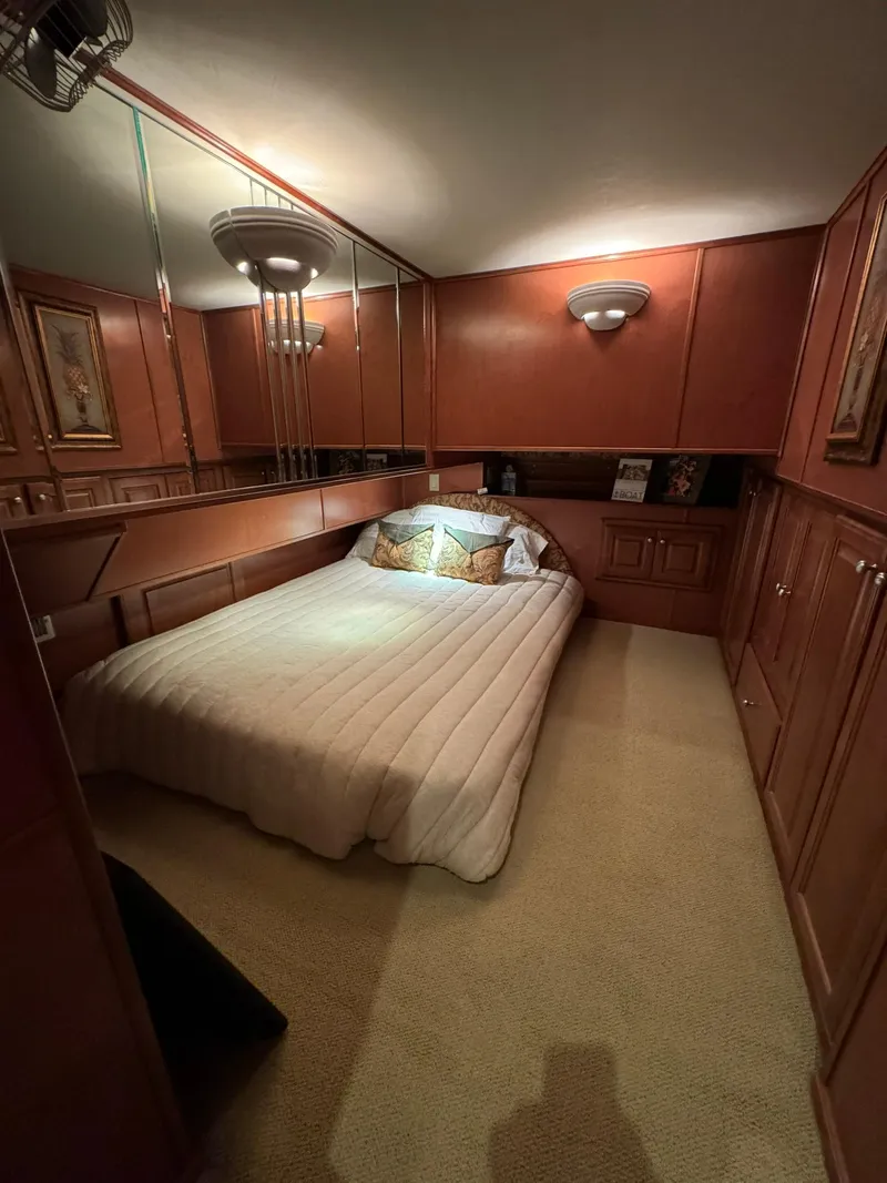 Slide: The Image of Luxurious bedroom in a 2003 Sharpe 75' Houseboat with wood paneling and cozy lighting. - 44