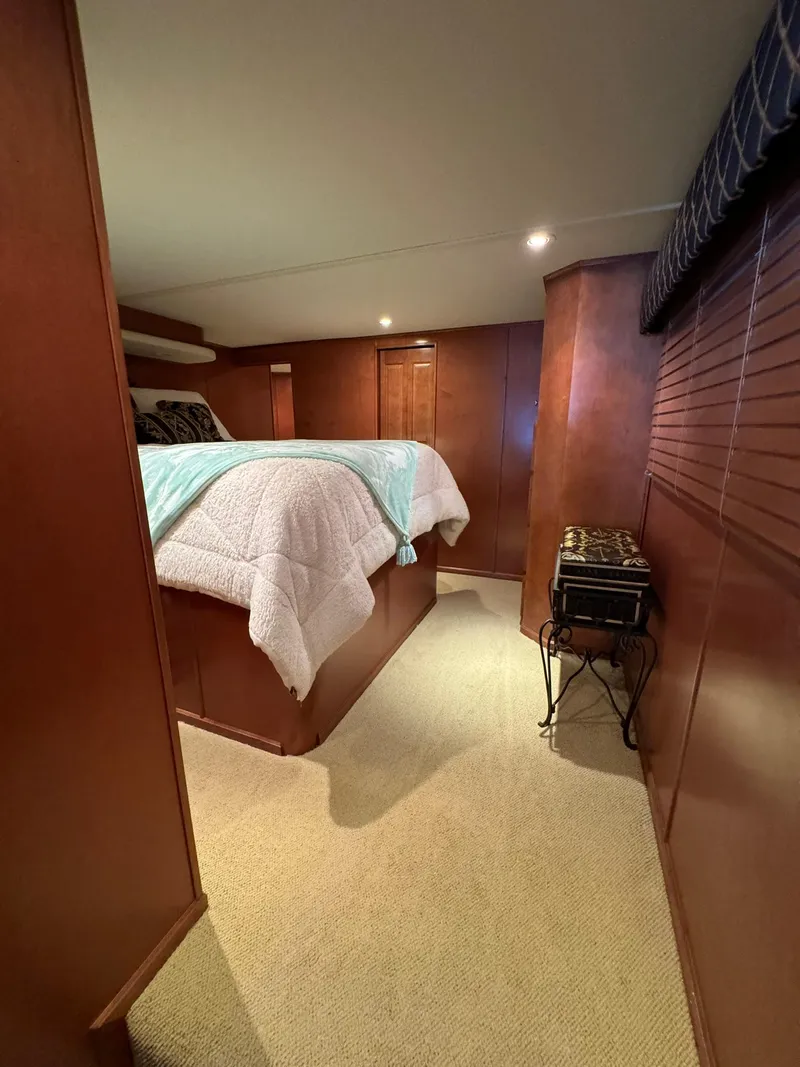 Slide: The Image of Cozy bedroom in a 2003 Sharpe 75' Houseboat with wooden interiors and a raised bed. - 46