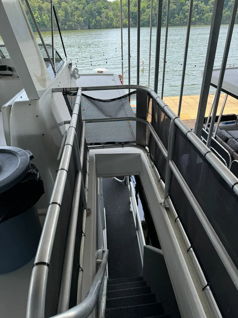 Slide: The Image of 2003 Sharpe 75' Houseboat with upper deck view and lake backdrop. - 9