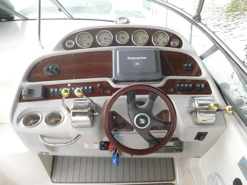 Slide: The Image of 2006 Chaparral 350 Signature boat dashboard with Raymarine navigation system and wooden steering wheel. - 25