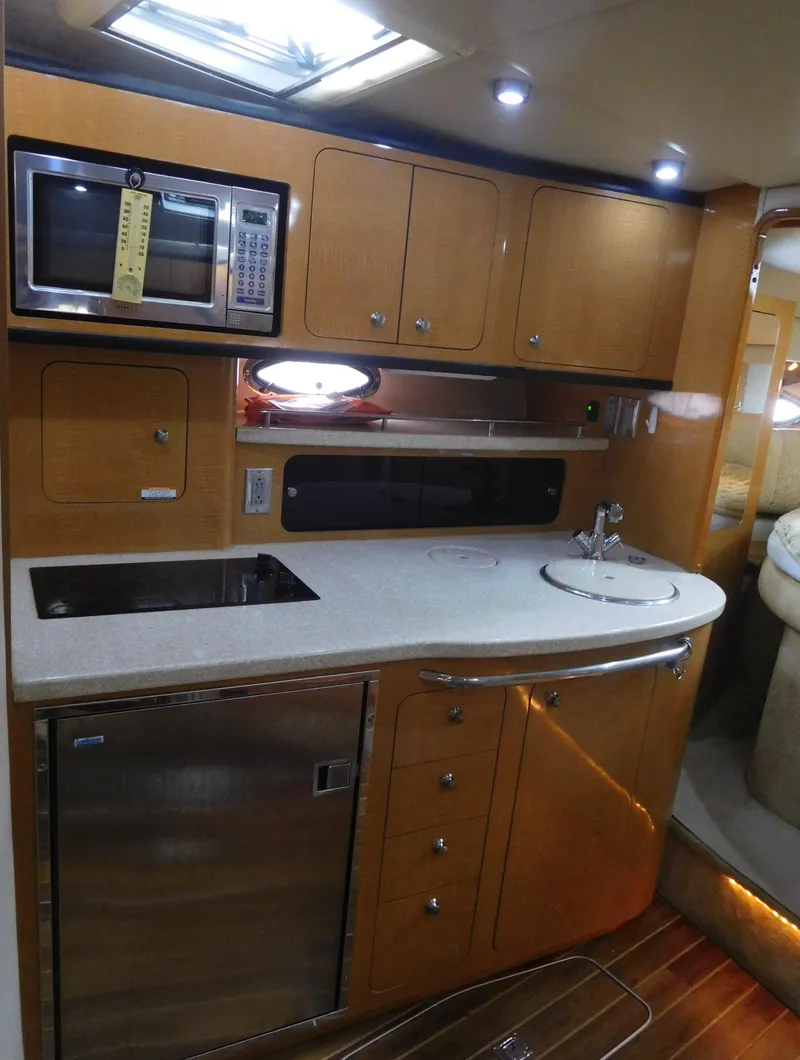 Slide: The Image of 2006 Chaparral 350 Signature yacht kitchen with microwave, sink, and fridge. - 44