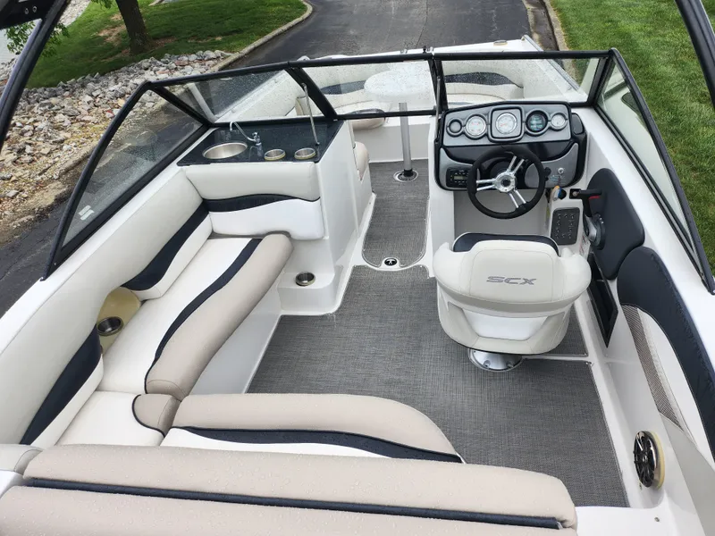 Slide: The Image of 2015 Starcraft Crossover 210 SCX IO boat interior with beige and black seating. - 10