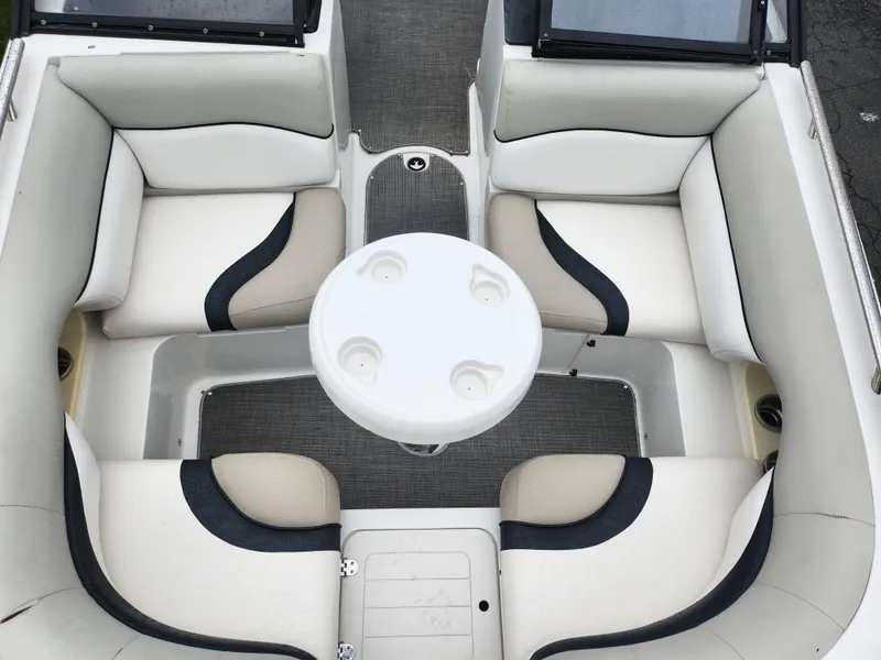 Slide: The Image of 2015 Starcraft Crossover 210 SCX IO boat interior with circular table and cushioned seating. - 17
