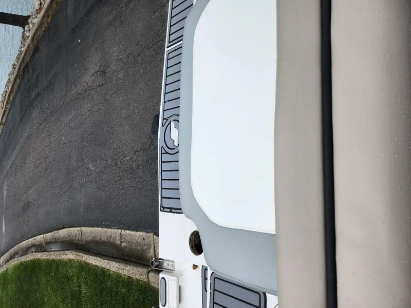 Slide: The Image of 2015 Starcraft Crossover 210 SCX IO boat docked by the water. - 24