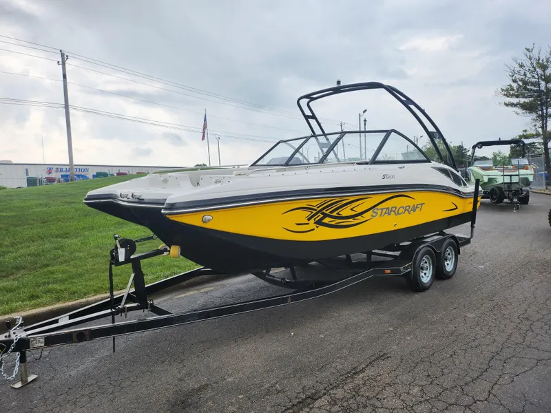 Slide: The Image of 2015 Starcraft Crossover 210 SCX IO boat on a trailer, yellow and black design. - 5